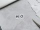 Aus Papierschnipseln gelegtes Wort „NO“ neben Laptop und Schere auf hellem Untergrund
